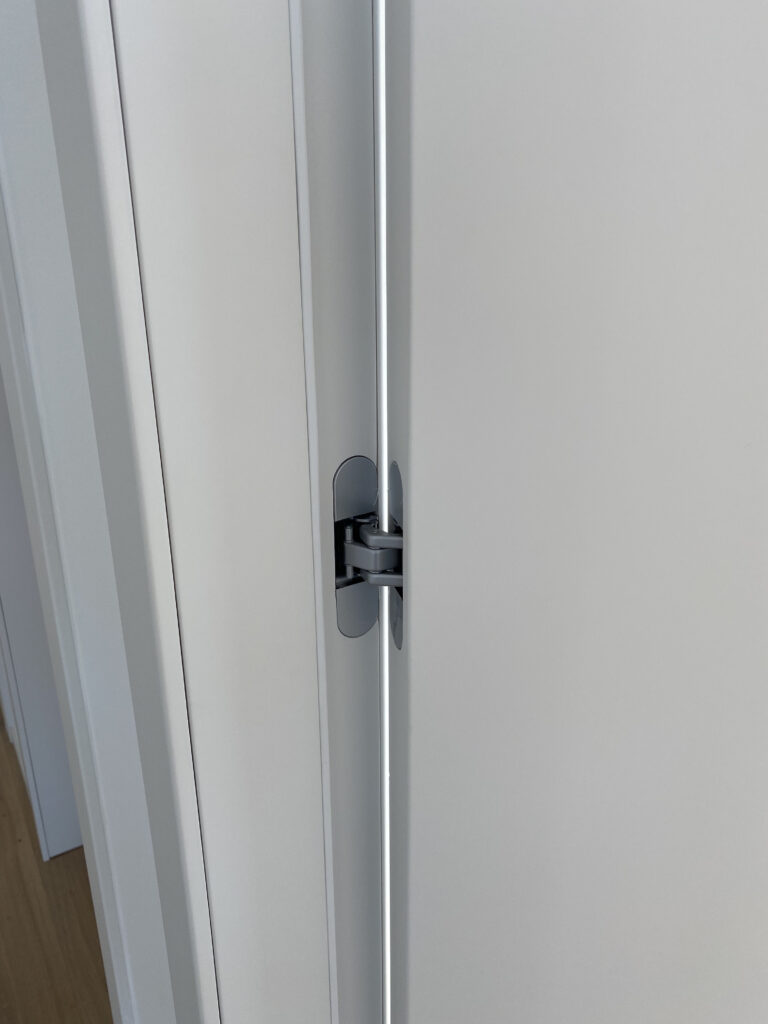 Dettaglio cerniera a scomparsa su porta laccata – Lessio Porte